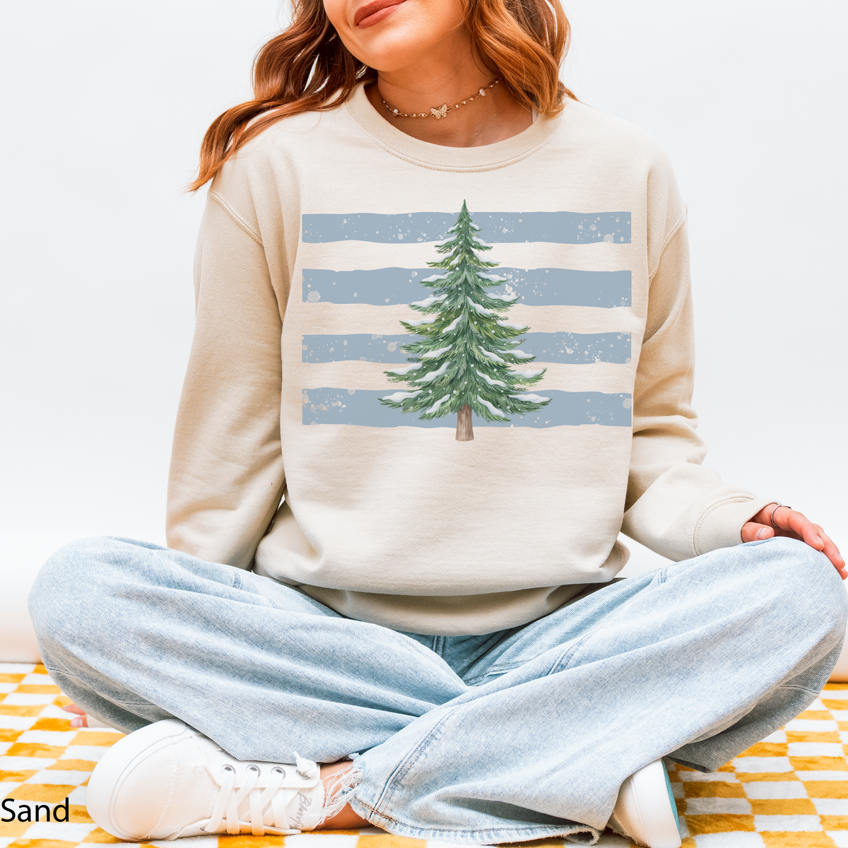 Sand crewneck sweatshirt with snowy Christmas tree graphic over dusty blue stripes